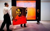 Служители на „Сотбис” носят картината на Уорхол „Мао”, на заден план творбата „Жезъл”, Герхард Рихтер
